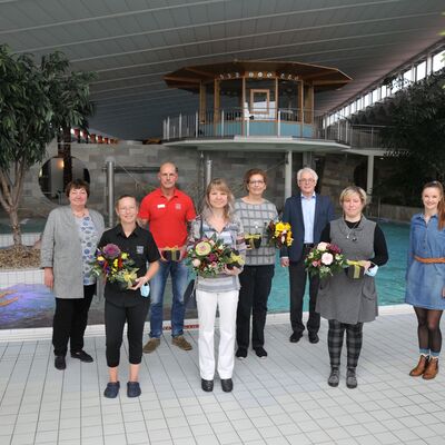 Foto: Eine Gruppe von Menschen steht vor einem Schwimmbecken.