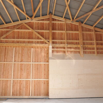 Foto: Eine große Holzhalle von innen.