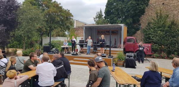 Bild vergr&ouml;&szlig;ern: Foto: Ein Konzert auf einer kleinen Bühne vor Publikum.