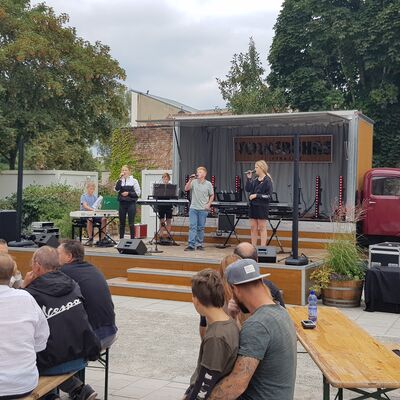 Foto: Ein Konzert auf einer kleinen Bühne vor Publikum.