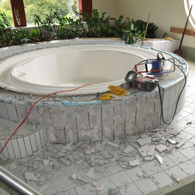 Foto: Ein Whirlpool, von dem die Fliesen teilweise abgeschlagen sind.