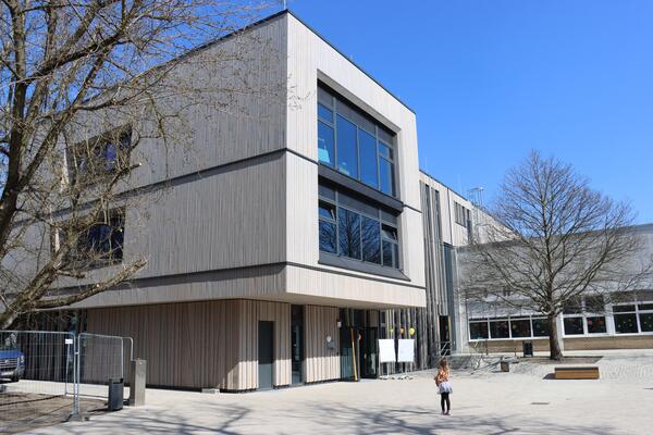 Bild vergr&ouml;&szlig;ern: Foto: Ein Mädchen vor einem großen Gebäude.