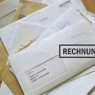 ein Stapel Briefe und Umschläge, ein Umschlag hat den Stempel "Rechnung" drauf