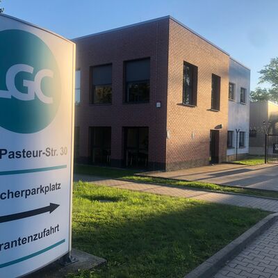 Foto: Ein Gebäude. Davor der Schriftzug "LGC" auf einem Schild.