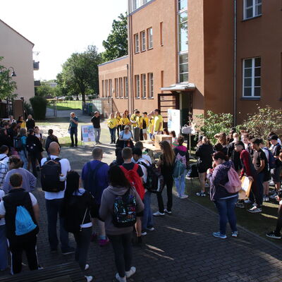 Bild vergr&ouml;&szlig;ern: Foto: Zahlreiche Menschen hinter einem großen Gebäude.
