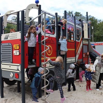Kinder spielen an der neuen Feuerwehr.