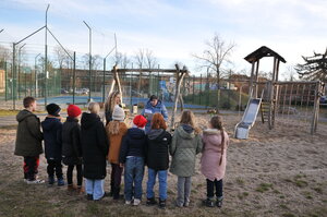 Bild vergr&ouml;&szlig;ern: Foto: Zwei Frauen und eine Reihe Kinder vor einem Spielplatz.