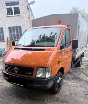 Bild vergr&ouml;&szlig;ern: Foto: Ein orangefarbener VW Transporter vor einem Gebäude.