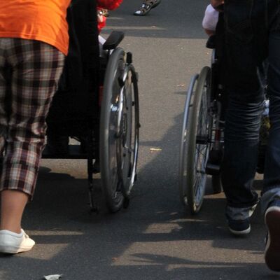 Rollstuhlfahrer werden geschoben