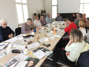Bild vergr&ouml;&szlig;ern: Foto: Menschen sitzen um einen Tisch.