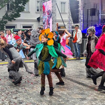 Bild vergr&ouml;&szlig;ern: Tänzerinnen in Kostümen performen vor Menschen.