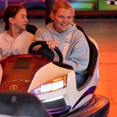 Bild vergr&ouml;&szlig;ern: Zwei Mädchen sitzen in einem Autoscooter.