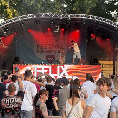 Bild vergr&ouml;&szlig;ern: Ein DJ steht au einer Bühne.