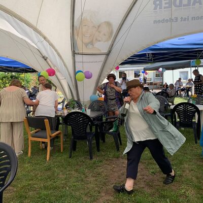 Bild vergr&ouml;&szlig;ern: Foto: Eine Frau läuft durch ein Pavillon-Zelt und hält eine Flasche in der Hand.