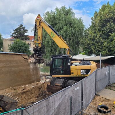 Foto: Ein Bagger beim Abriss eines kleinen Gebäudes.