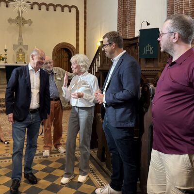 Menschen stehen in einer Kirche.