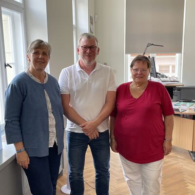 Foto: Zwei Frauen und ein Mann in einem Büroraum.