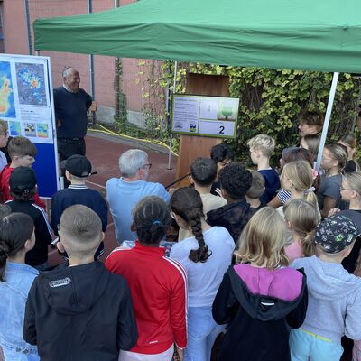 Bild vergr&ouml;&szlig;ern: Foto: Viele Kinder stehen um einen grünen Pavillon herum.