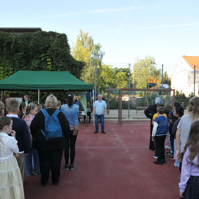 Bild vergr&ouml;&szlig;ern: Foto: Viele Kinder und einige Erwachsene auf einem Schulhof.