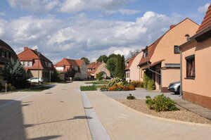 Bild vergr&ouml;&szlig;ern: Foto: Eine neusanierte Straße mit Häusern und Vorgärten.
