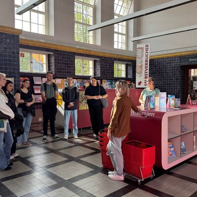 Bild vergr&ouml;&szlig;ern: Menschen stehen im Foyer einer Bibliothek.