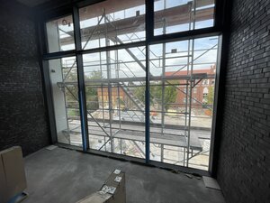 Bild vergr&ouml;&szlig;ern: Foto: Blick durch eine Glasfront in einem eingerüsteten Gebäude.
