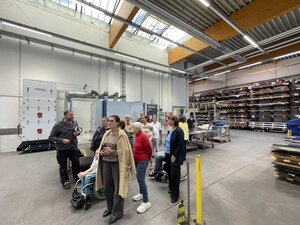 Bild vergr&ouml;&szlig;ern: Foto: Eine Gruppe Menschen steht in einer großen Halle.