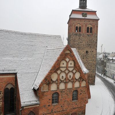 Foto: Der Luckenwalder Marktturm und die Kirche im Schnee.