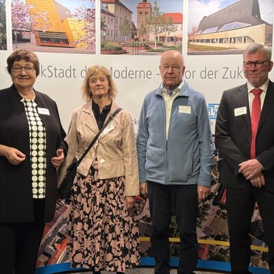 Foto: Zwei Frauen und zwei Männer vor einer Fotowand.