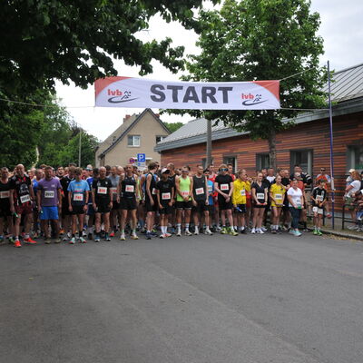 Foto: Zahlreiche Menschen in Sportklamotten unter einem Banner mit der Aufschrift "Start".
